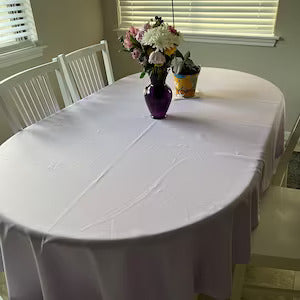White oval tablecloth with flowers on the table