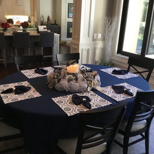 Blue oval tablecloth, blue cloth napkins and white placemats