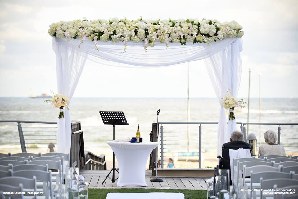  White Spandex table cover on a wedding ceremony stage table outdoors by the beach