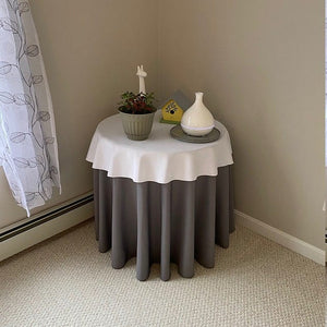 Layered white and green Poly table linens with home articles on top