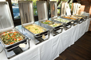 Professional table linens on buffet tables with food trays on top
