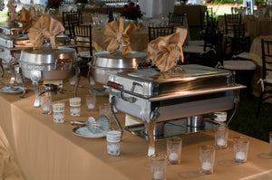 Quality wedding linens on a buffet table with hot food trays on top