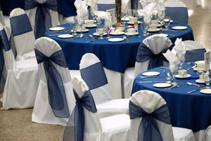 Wedding linens layered with matching chair covers and sashes