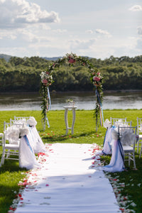 white burlap aisle runner at an outdoor wedding ceremony by a river