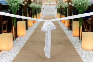 Natural burlap aisle runner at a wedding ceremony inside a church