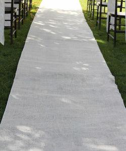 white burlap aisle runner at an outdoor wedding reception on the grass