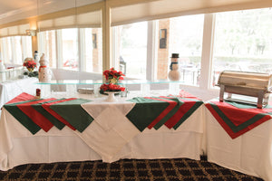 Multi-color table linens and napkins on buffet tables for a company Holiday party