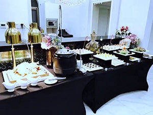 A black spandex table cover's placed on a carving and desert station during a wedding reception