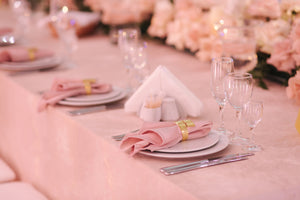 Wedding linens with matching napkins inside rings and wine glasses