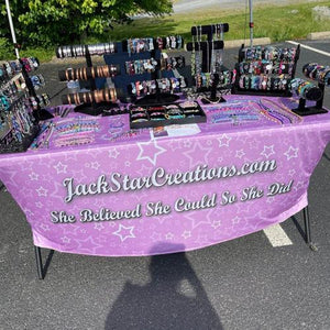 Fully printed spandex table cover with a pink background and white letters for Jack Star creations