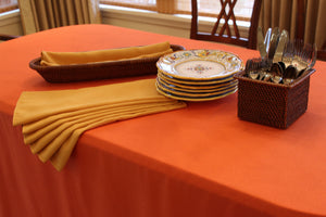 Folded Havana napkins stacked on a table next to plates and silverware