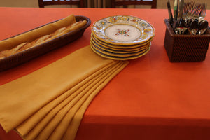 Havana napkins in Orange with matching tablecloth with stacked plates and cutlery