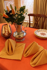 Elegant Havana napkins folded in a triangle form on top of a table with flowers