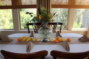 Fine linen napkins on family table with matching runner and baby squash