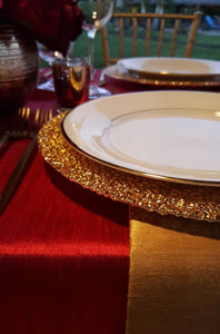Red Majestic Dupioni tablecloth and gold napkins with charger and dishes on the table
