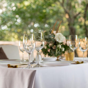 White wedding tablecloth, tan napkins, plates and wine glasses