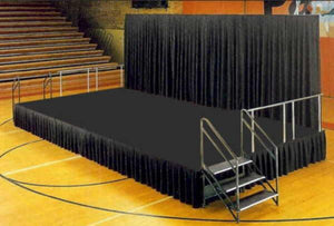 Black stage skirt set up on a stage in a school gymnasium 
