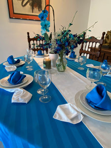 Blue oval tablecloth with white flowers on the table