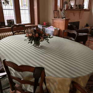 Poly Stripe Oval Tablecloth  with a vase of flowers