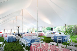 Checkered tablecloth wedding reception under a tent.