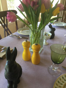White dinner linens on Easter celebration table with tulips and bunny statuettes
