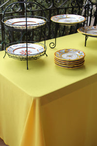 Formal linens on serving station table in an outside area with colorful plates