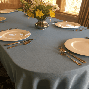 Havana tablecloth in Charcoal color at a family dining room setting with plates, cutlery and flowers