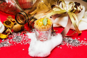 Holiday red colored tablecloth in a photo shoot set up with bottles, glasses, and ribbon