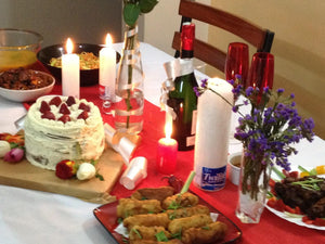Rectangular White tablecloth with a red runner and food in a home setting