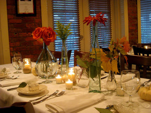 Rectangular table with white tablecloth, plates and flowers at a retaurant