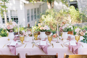 Elegant wedding linens in an outdoor reception setting with plates and napkins