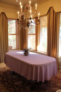 White Spun linen on a table in a dining room with a centerpiece by a window