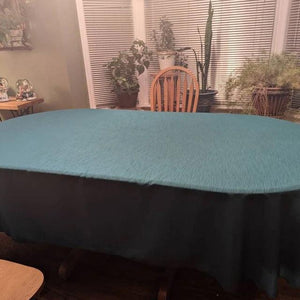 Fine table linens on oval shaped table at a family dinner table