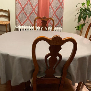 Round linens on a table for 4 in a family room with wooden chairs