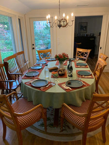 Spun poly table linens at home dinner with silverware and places for nine by a window