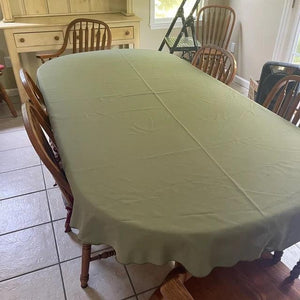 Tan tablecloth on an empty table in a home with chairs