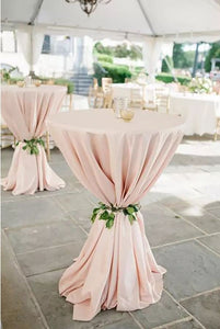 Poly premier table linens on a cocktail table tied at the center. 