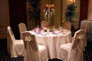 Round poly linens with matching chair covers and satin wedding sashes