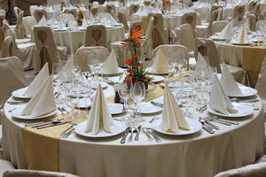 Wedding linens on tables at a large high end wedding reception with standing pointed napkins
