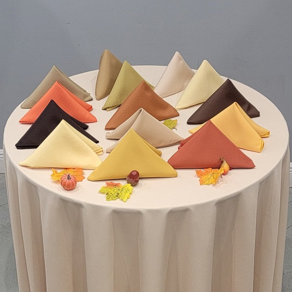 Fall colored napkins folded into triangles on top of a round table