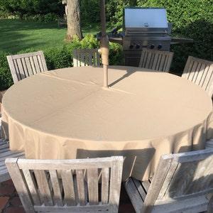 Round table linens in an outdoor table with an umbrella hole