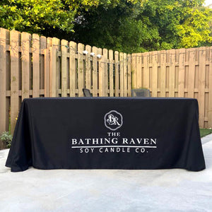 Black custom-printed tablecloth with white logo print for Bathing Raven Soy Candles