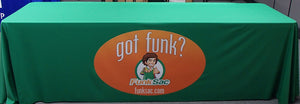 Green custom tablecloth with company logo on the front panel at a tradeshow.