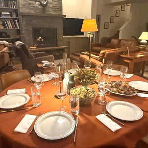Burnt orange tablecloth, fall table cloth with china and food on the oval table