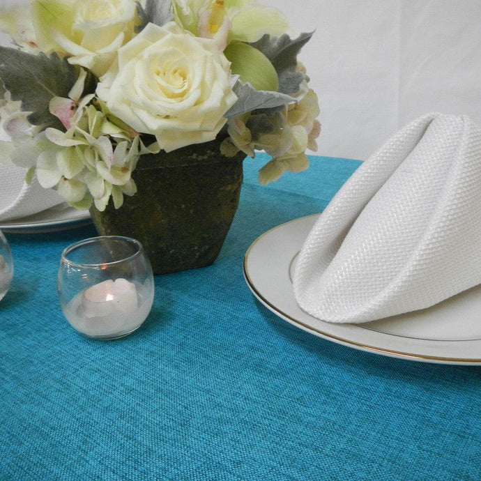 Blue linen tablecloth and cotton napkins on an elengant tablescape