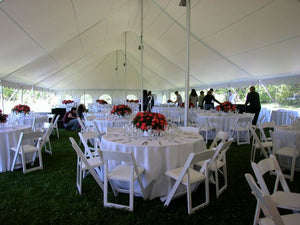 Multiple Havana linens on round tables for an outdoor reception under a tent