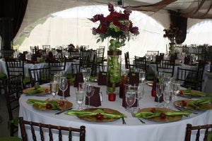 Outside wedding reception with round Havana table linens on tables with gold accents