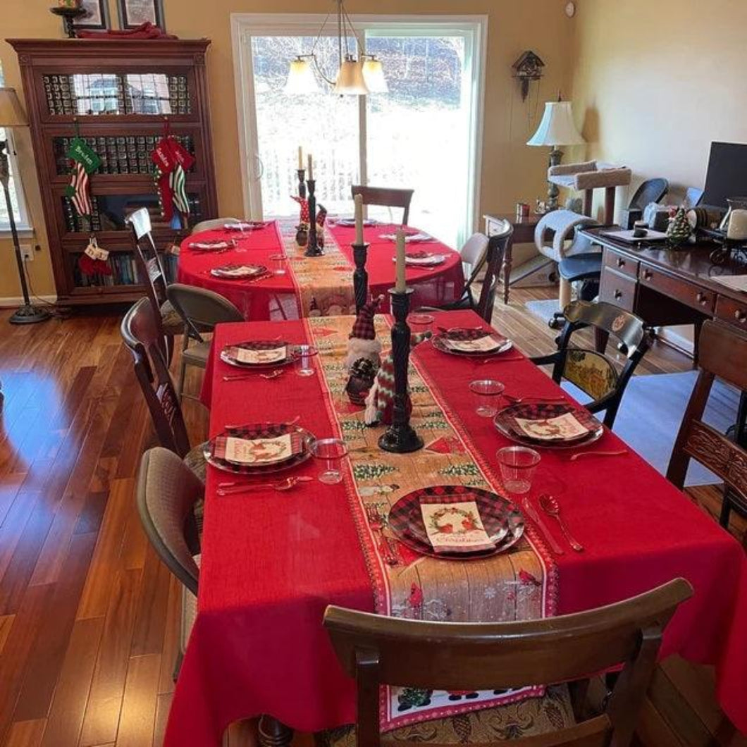 Rectangula and oval tablecloth, holiday red with table runnrs and holiday decorations on the table.