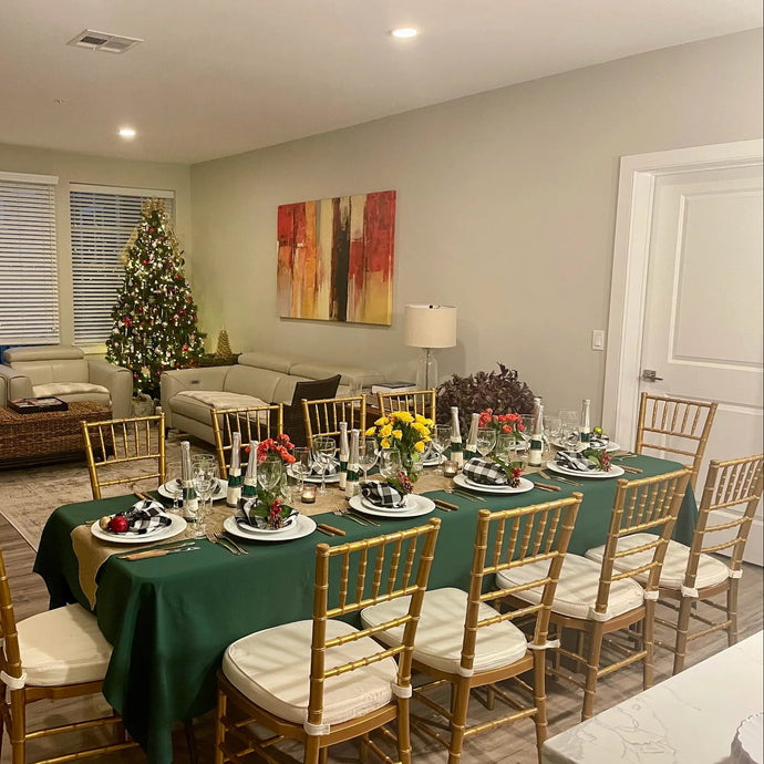 Christmas green tablecloth in a dining room with a Christmas tree, table set for dinner, and decorative elements.
