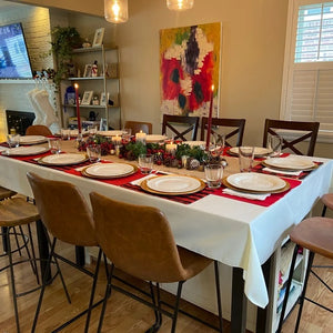 Classy dinner table dressings on a home holiday table with plates and tall red candles